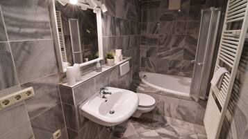 Une salle de bain moderne avec un lavabo, des toilettes et une baignoire.
