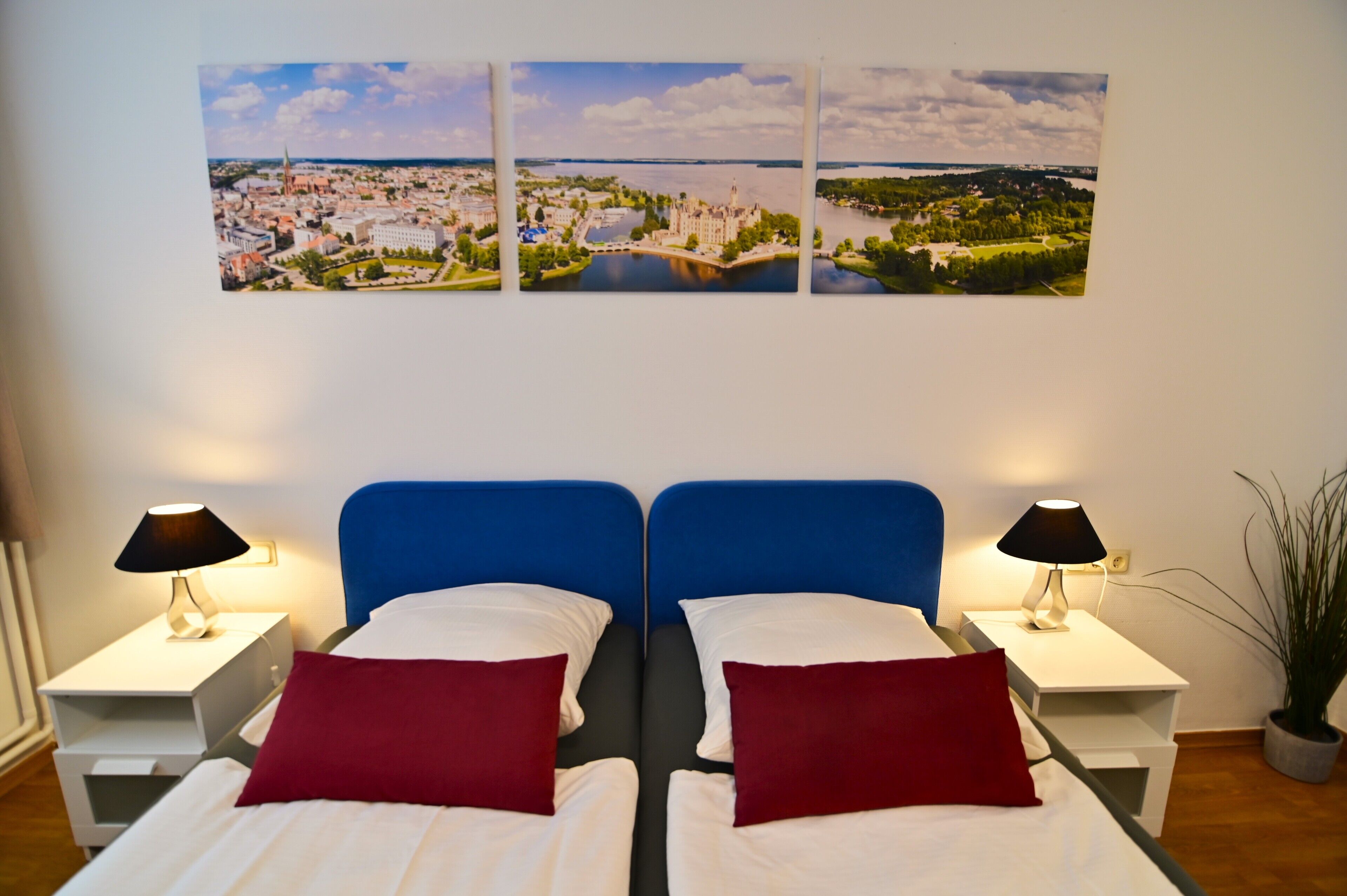 A hotel room with two beds, a large window, and a cityscape view.