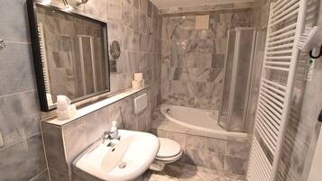 A modern bathroom with a sink, toilet, and bathtub.