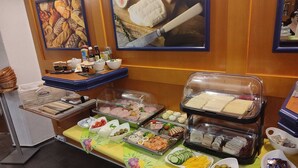 Montaje tipo buffet con diversas opciones de comida, como sándwiches, frutas y salsas.