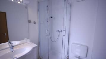Une salle de bain avec une douche à parois de verre, un lavabo et des toilettes.