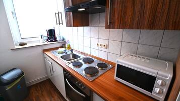 A kitchen with a stove, microwave, and sink.