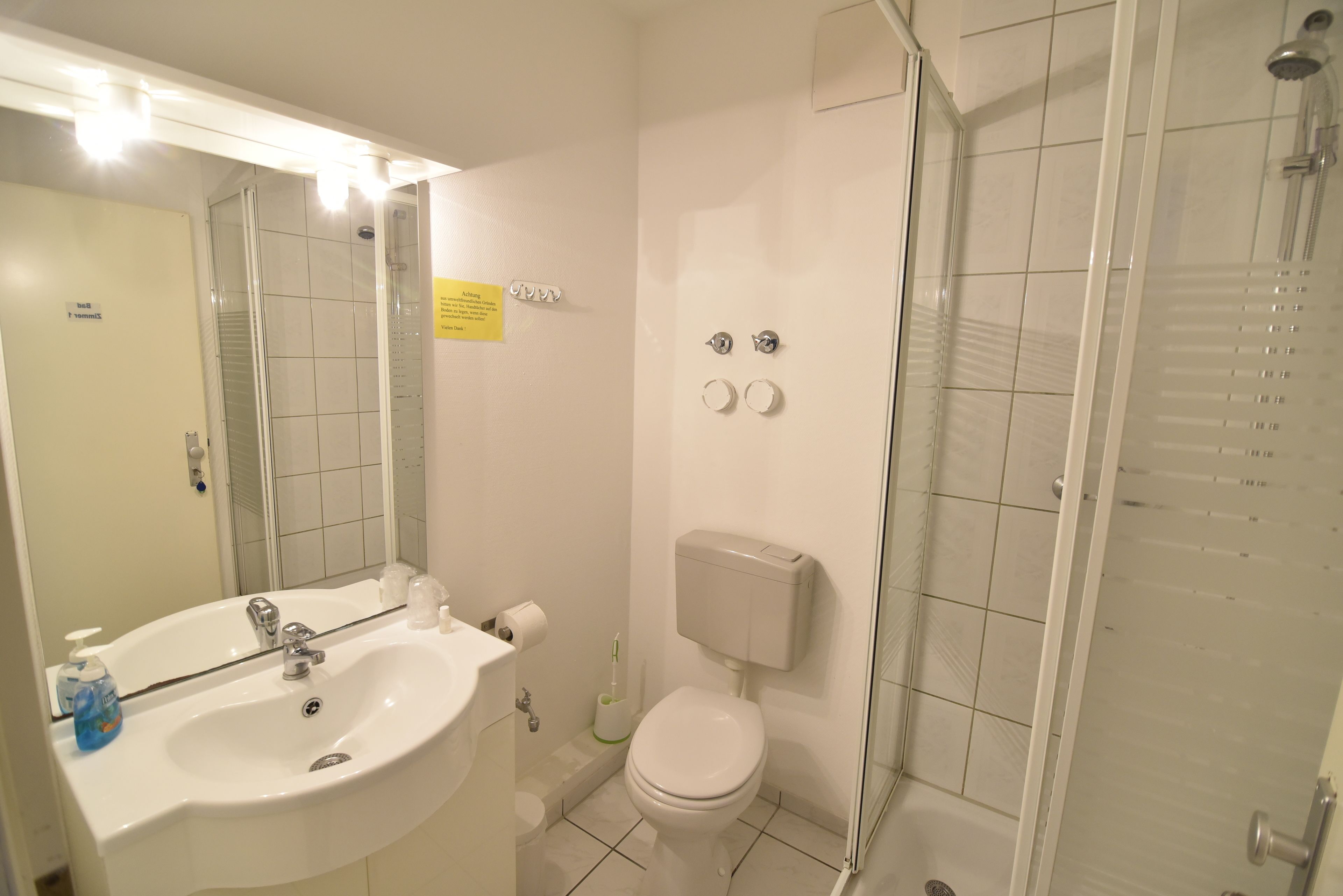 A bathroom with a sink, toilet, and shower.