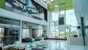 A spacious lobby with a high ceiling, a large window, and a modern chandelier. - Holiday Inn Queretaro Zona Krystal by IHG (Querétaro)