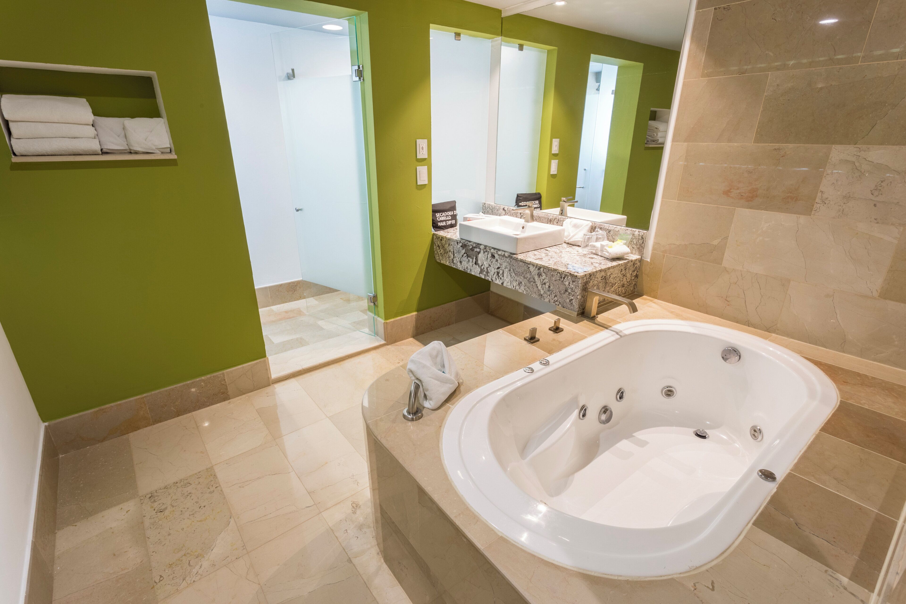 Un baño moderno con una bañera grande, dos lavamanos y un espejo.