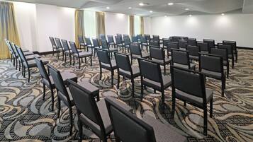 A conference room with rows of chairs and a patterned carpet.