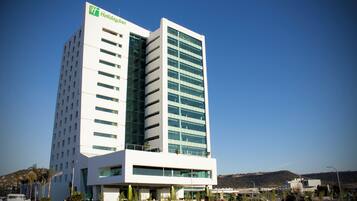Un moderno hotel Holiday Inn con una fachada de vidrio destacada, varios pisos y un techo plano.
