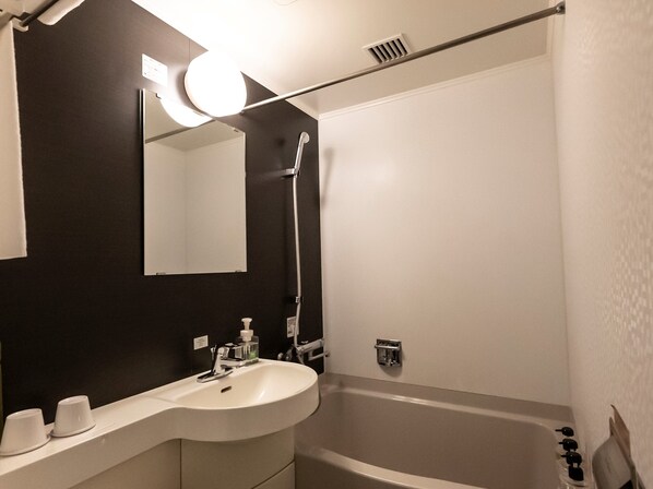 A modern bathroom with a curved sink, a mirror, a shower, and a towel rack. - ibis Styles Kyoto Station (Kyoto)