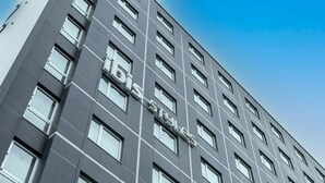 Un edificio moderno con una fachada de ventanas en forma de cuadrícula y un llamativo letrero 'BIS' que indica el nombre.