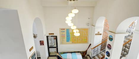 Eine Treppe mit einem gemusterten Boden, einer hängenden Leuchte und einer Wand mit einer Karte und dekorativen Elementen.