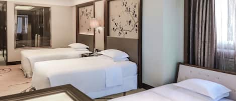 A hotel room with two beds, a large mirror, and a decorative wall panel.