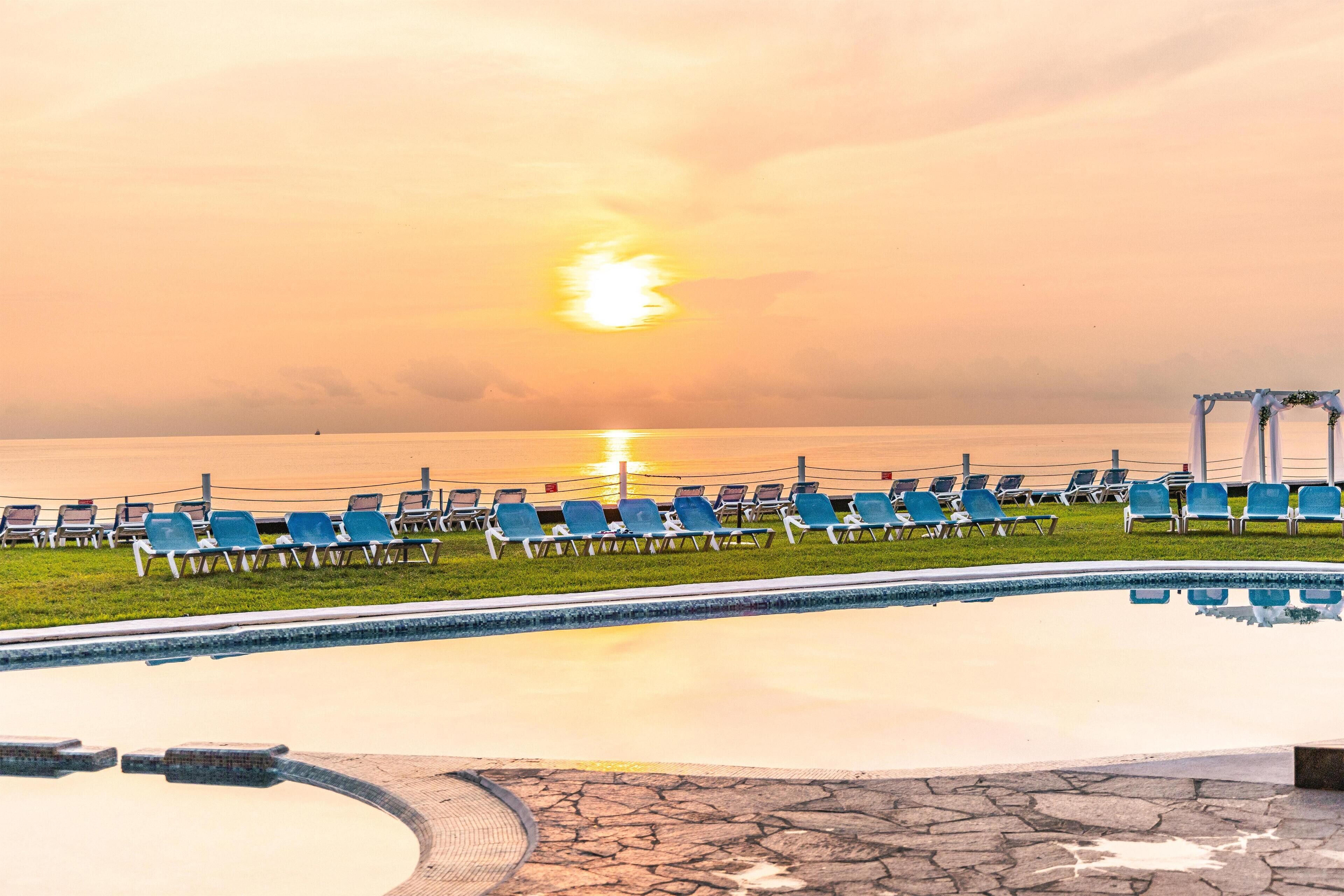 Alberca al aire libre y camastros 