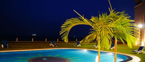 Una piscina al aire libre, tumbonas