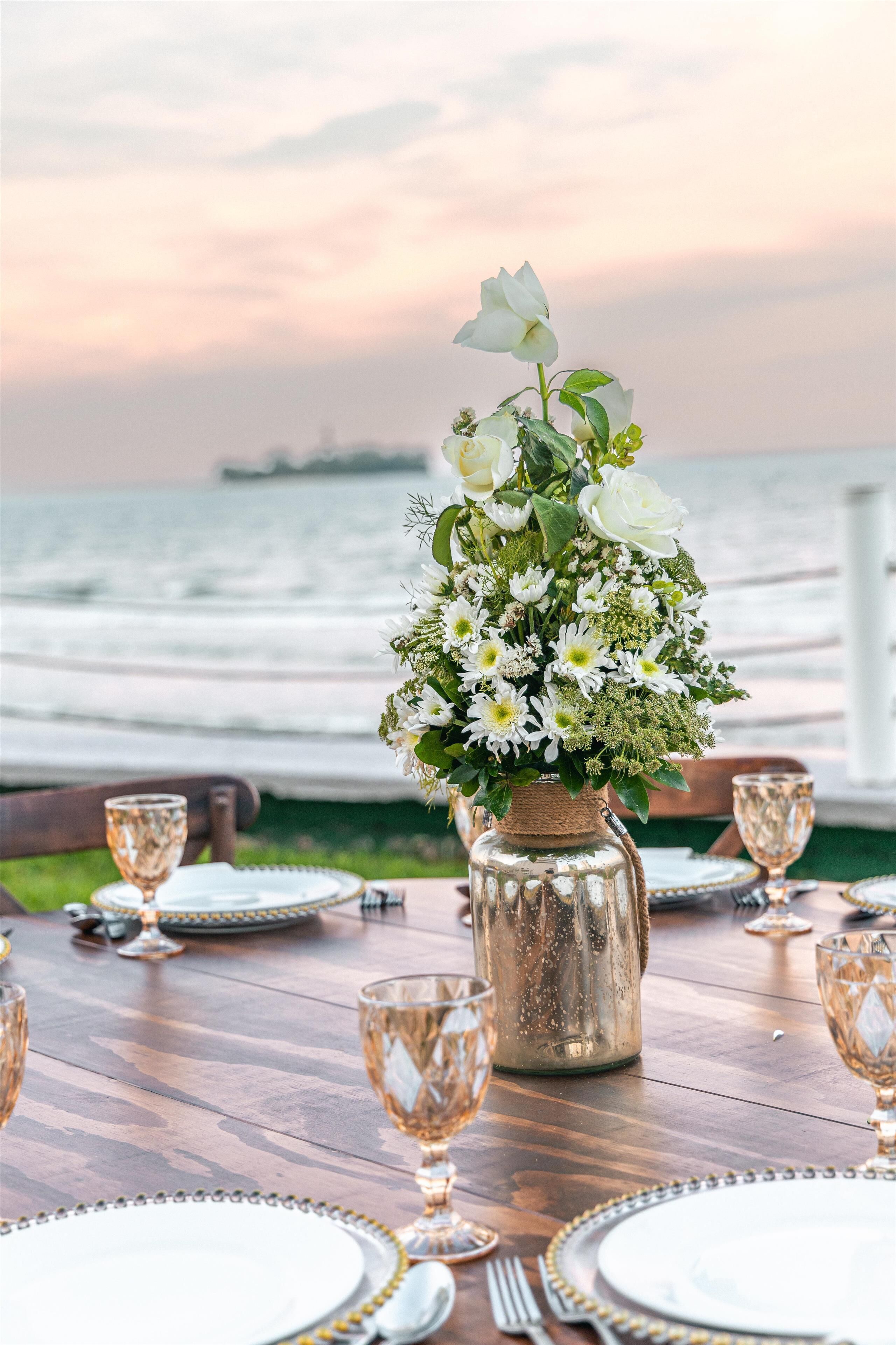 A table set for dining with a view of the ocean.