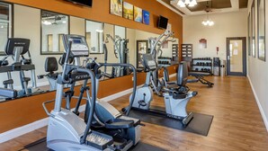 A gym with multiple cardio machines, mirrors, and a shoe display. - Comfort Suites Batesville (Batesville)