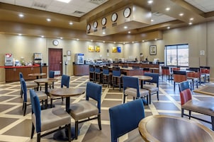Un vestíbulo de hotel con mostrador de recepción, zona de estar y estación de café.