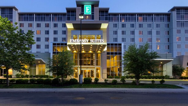 A hotel with a prominent entrance, multiple floors, and a well-lit facade. - Embassy Suites Newark Airport (Elizabeth)