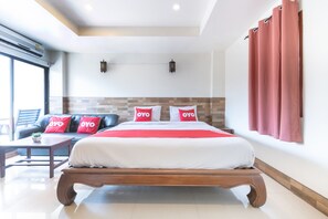 Een moderne hotelkamer met een groot bed, een bank en een klein tafeltje.