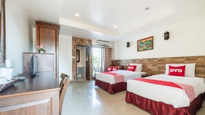 A hotel room with two beds, a desk, and a view of the outdoors. - Chaba Garden Resort & Service (Pattaya)
