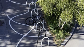 Zona de estacionamiento para bicicletas con un aparcamiento y un cubo de basura.