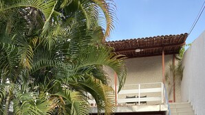 A building with a covered outdoor area, a staircase, and a reception desk. - Pousada Nossa Casa (Maceió)