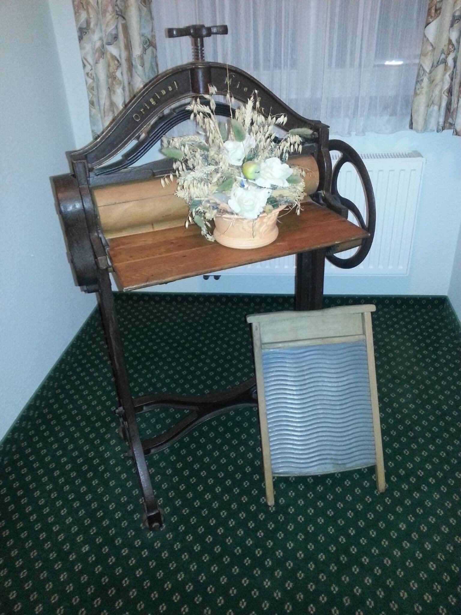 A vintage-style chair with a wooden backrest and a small table with a floral arrangement.