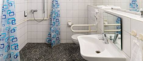 A bathroom with a shower, toilet, and sink.