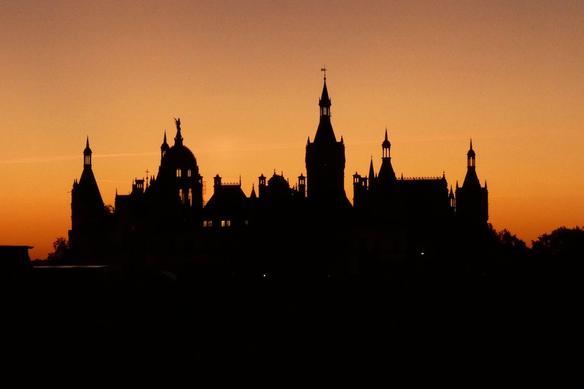 A silhouette of a historic building complex at sunset.