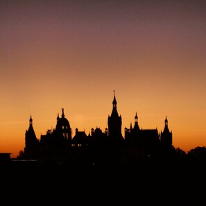 A silhouette of a historic building complex at sunset. - Hotel Am Schloß (Schwerin)