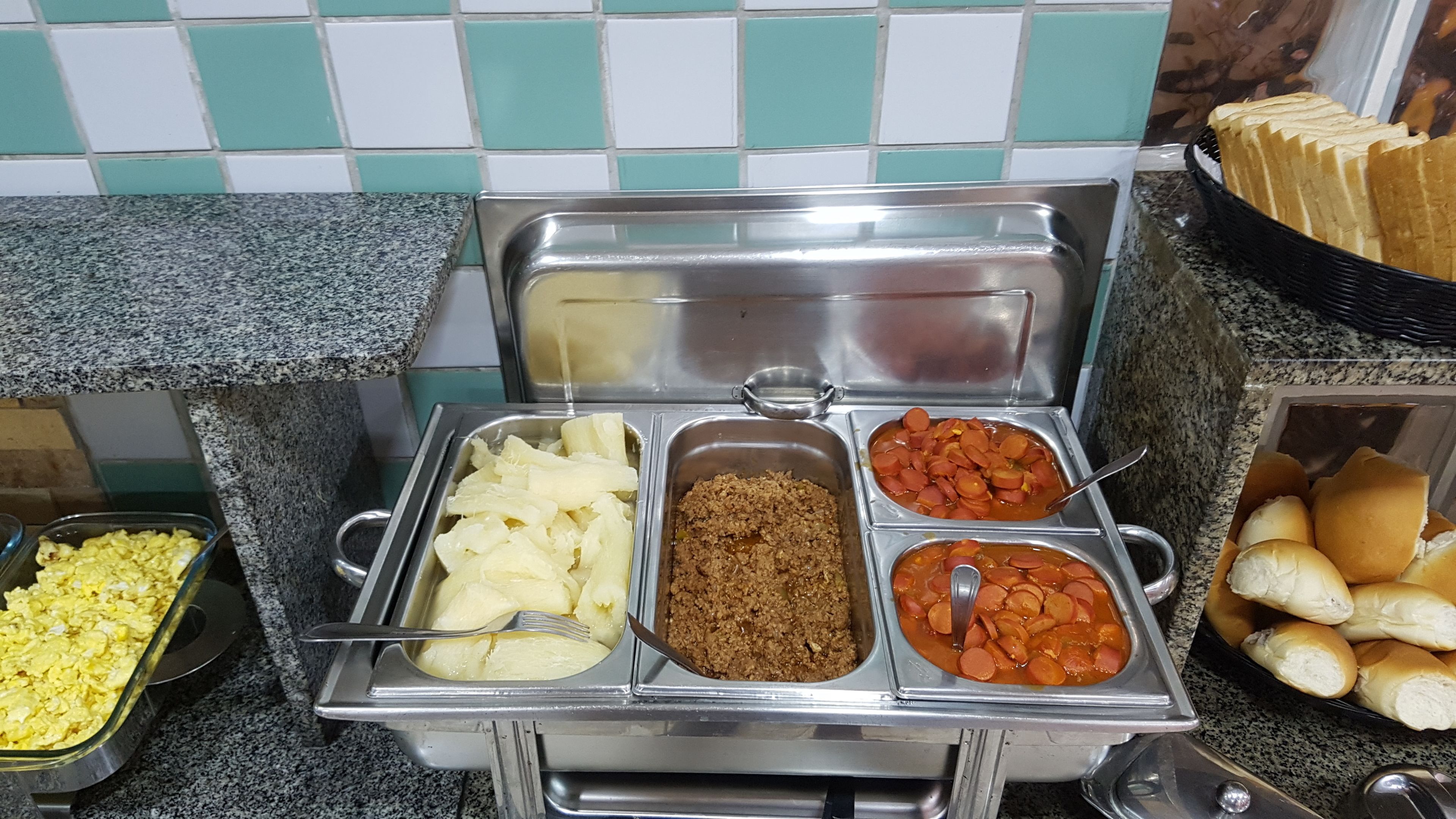 A buffet with various food options including potatoes, meat, and sausages.