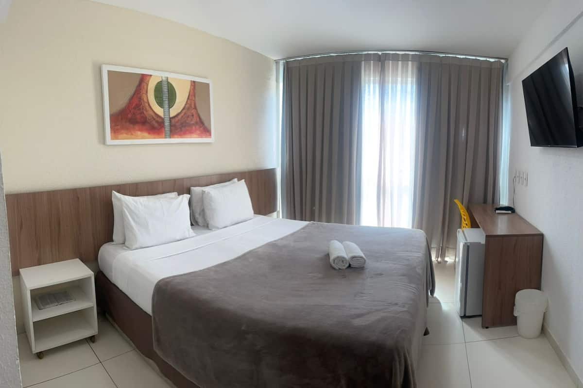 Minibar, escritorio, cortinas blackout y tabla de planchar con plancha