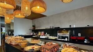 A buffet area with various food items and wicker pendant lights. - Hotel Pousada Gogo da Ema (Maceió)