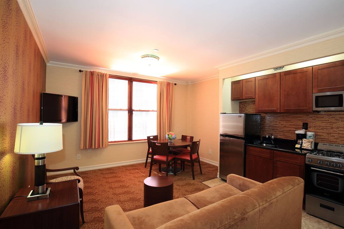 A compact living space with a dining area, kitchen, and a sofa.