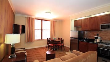 A compact living space with a dining area, kitchen, and a sofa.
