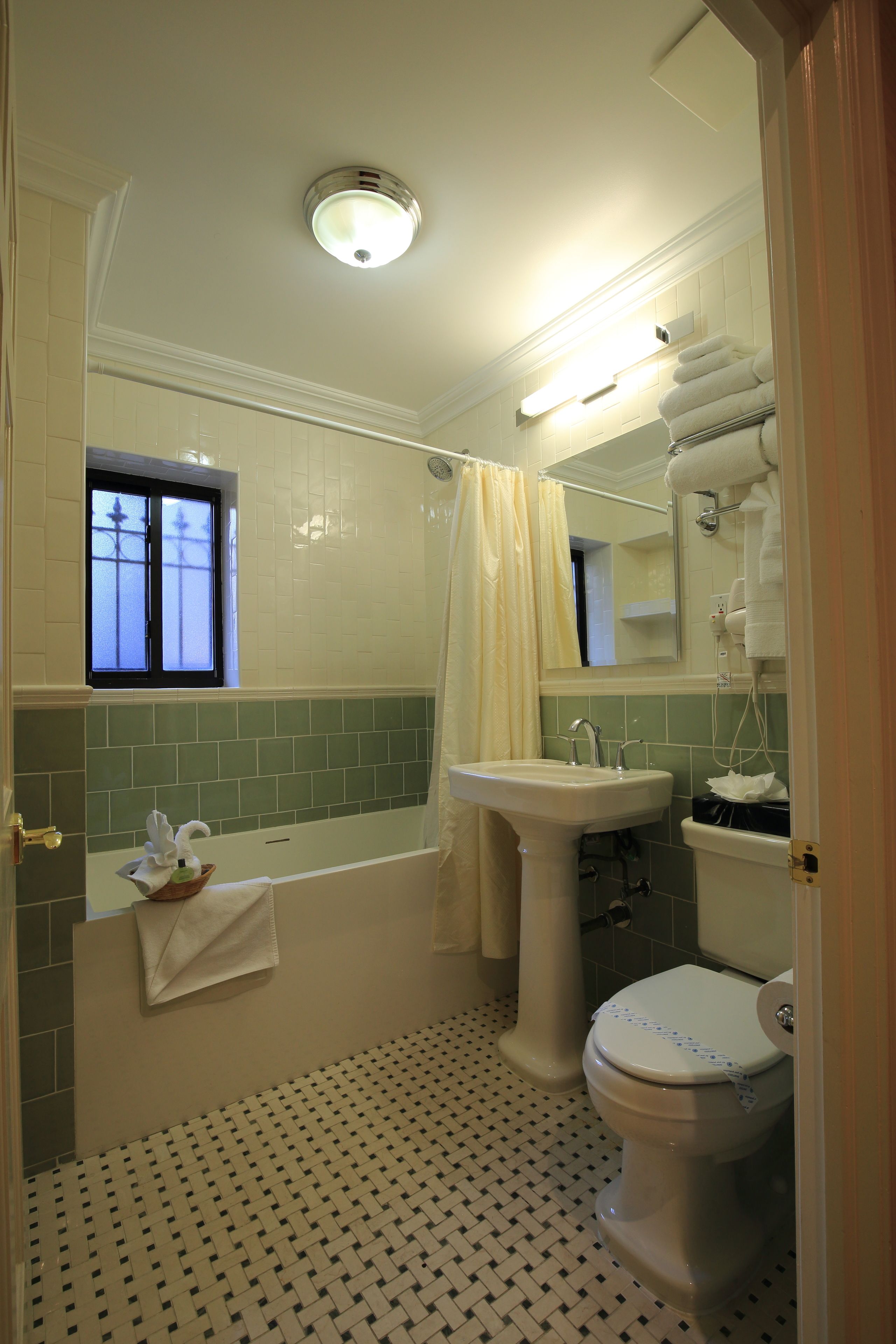 Un baño con bañera, lavamanos e inodoro.