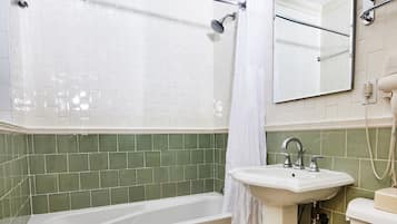 A bathroom with a bathtub, sink, toilet, and a shower curtain.