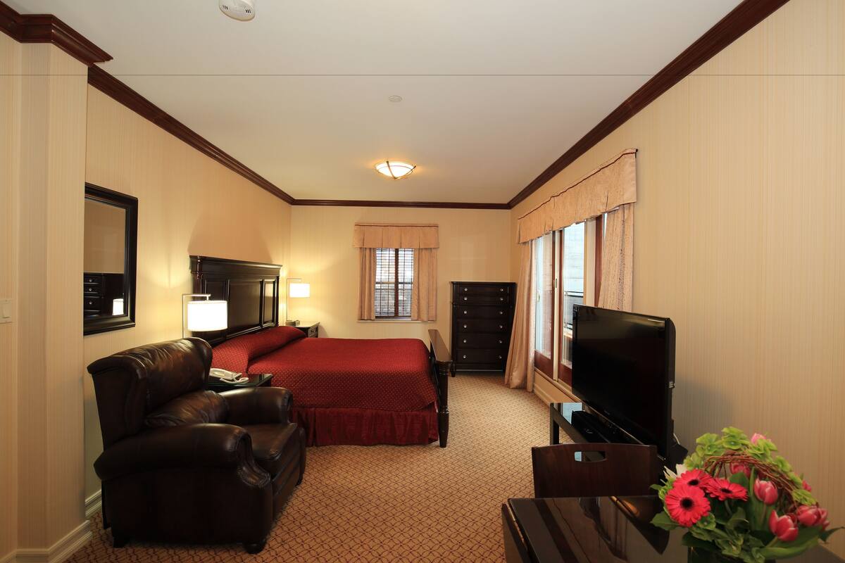 Une chambre d’hôtel équipée d’un lit, d’une télévision, d’un bureau, d’une chaise et d’une lampe.