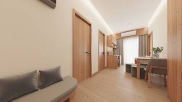 A modern hotel room with a wooden floor, a sofa, a dining area, and a kitchen.