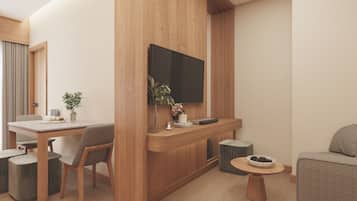 A modern living room with a wooden accent wall, a flat-screen TV mounted above a wooden console, a dining area with a table and chairs, and a round coffee table with a bowl of pinecones.