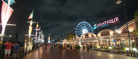 A waterfront promenade with a Ferris wheel and a restaurant named 'TASIATIQUE'.