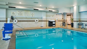 Une piscine intérieure équipée d’un élévateur pour faciliter l’accès à l’eau, d’un panneau indiquant qu’il est interdit de plonger, et d’un avertissement concernant la recirculation de l’eau.