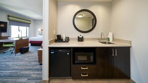 A compact hotel room with a kitchenette, a bed, a desk, and a television. - Hampton Inn & Suites Salinas (Salinas)