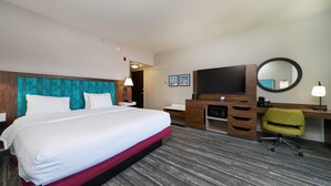 A hotel room with a large bed, a desk with a flat-screen TV, a chair, and a mirror. - Hampton Inn & Suites Salinas (Salinas)