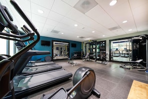 A gym with treadmills, exercise bikes, and weight machines.