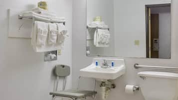 Une salle de bain d’hôtel standard, équipée d’un lavabo, de toilettes et d’un miroir.