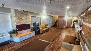 Un vaste espace de vie doté d’une cheminée, d’un canapé, d’une table basse et d’un mur décoratif en bois.