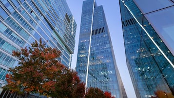 A modern high-rise building with reflective glass windows and a prominent vertical light strip.