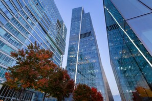 A modern high-rise building with reflective glass windows and a prominent vertical light strip.
