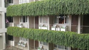 Un edificio con varios balcones cubiertos de vegetación.