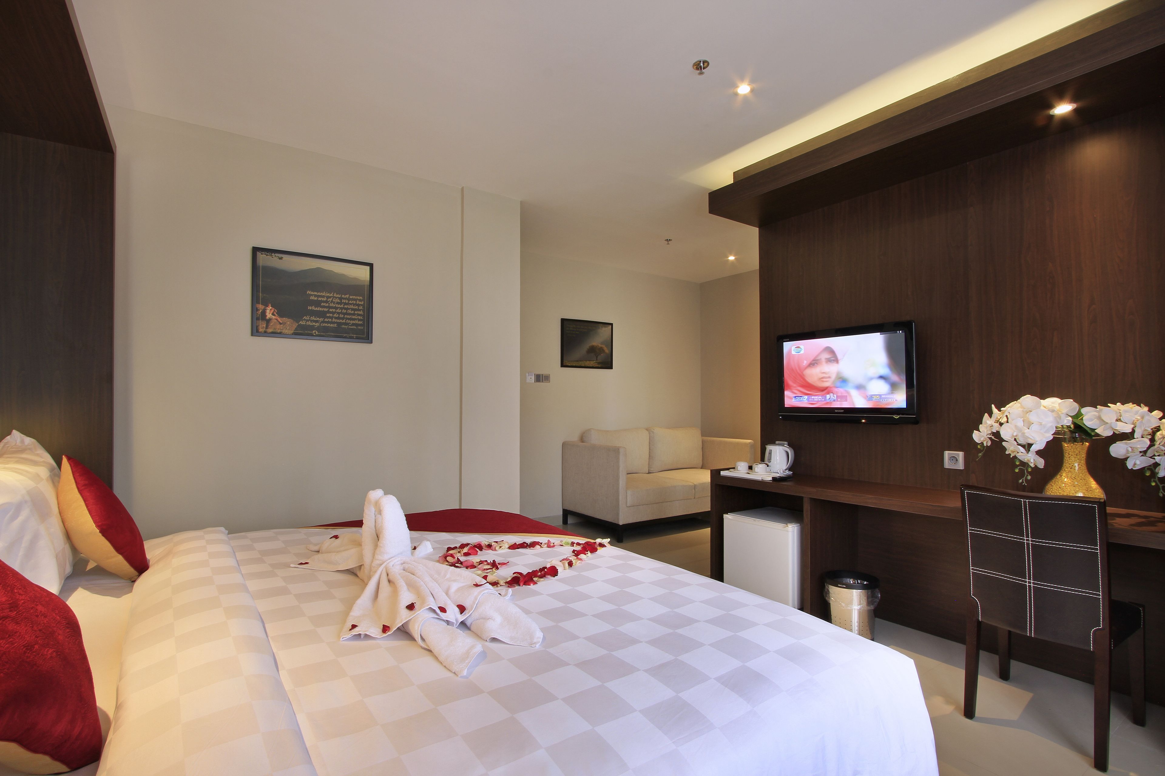 Habitación de hotel con cama, televisión, escritorio y silla.
